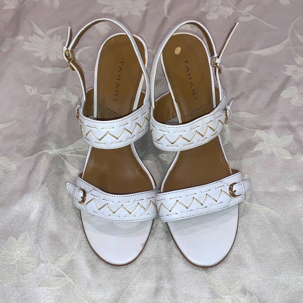 White sandals, with decorative stitching and gold accents